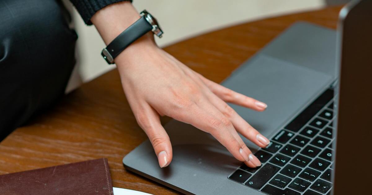 Person typing on laptop keyboard